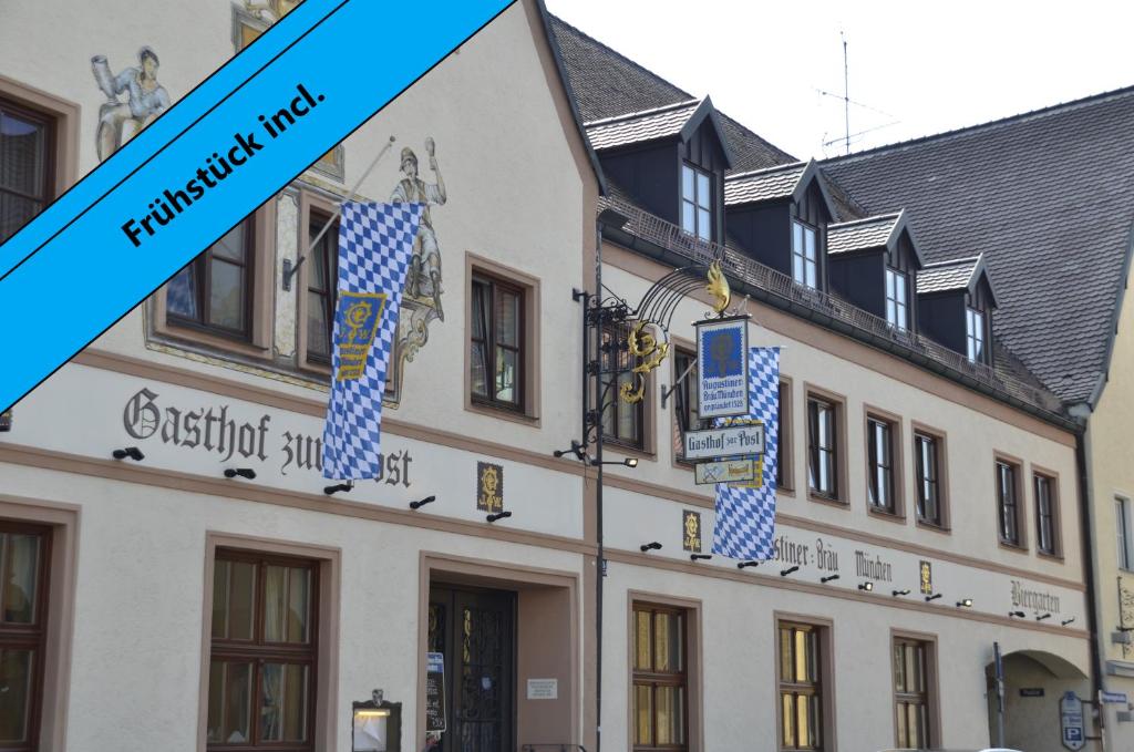 a building with blue and white signs on it at Gasthof Zur Post in Wolnzach