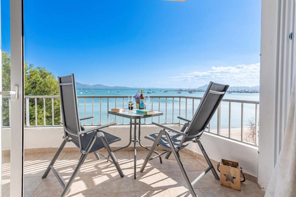 a balcony with a table and chairs and the ocean at On The Beach Voramar by Sealand Villas in Port de Pollensa