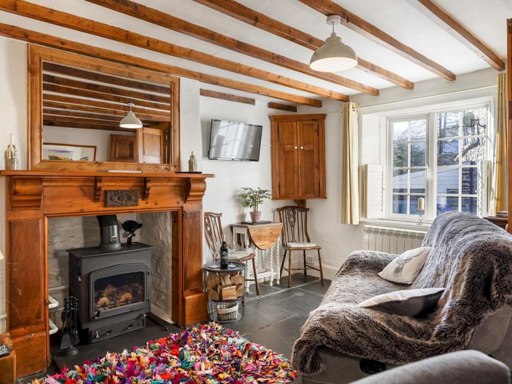 a living room with a fireplace and a couch at Pass the Keys Cosy Cottage in Corris One wellbehaved dog welcome in Machynlleth