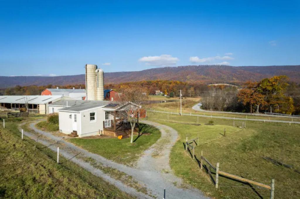 a farm with a white house and a dirt road at Oakbend Cottage in Newville