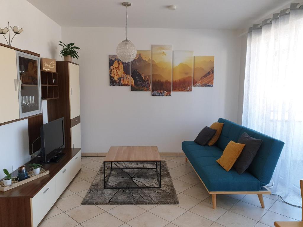 Sala de estar con sofá azul y mesa de centro en Ferienwohnung Bergsteiger en Strassen