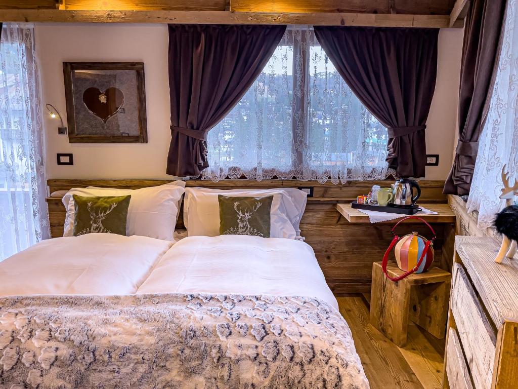 a bedroom with a large bed in front of a window at Hotel da Beppe Sello in Cortina dʼAmpezzo