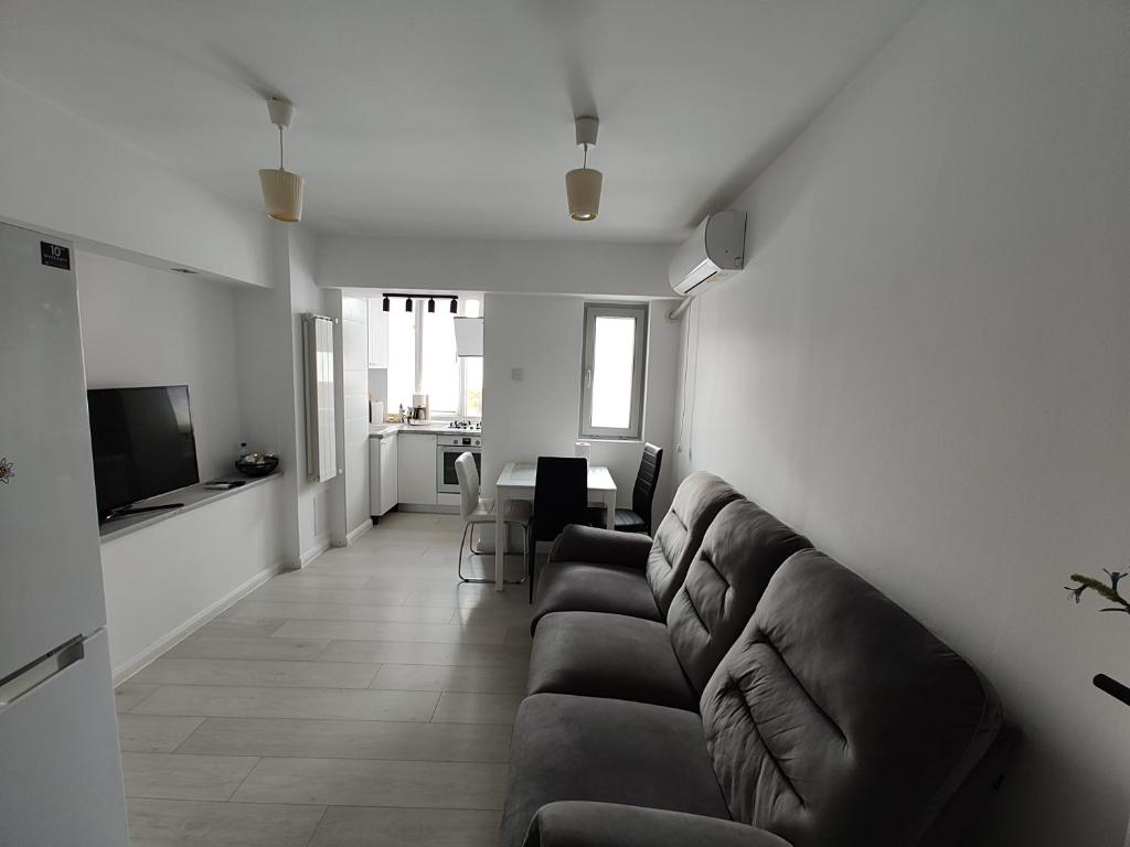 a living room with a couch and a television at Ultracentral Ploiesti Apartment-Free Private Parking in Ploieşti