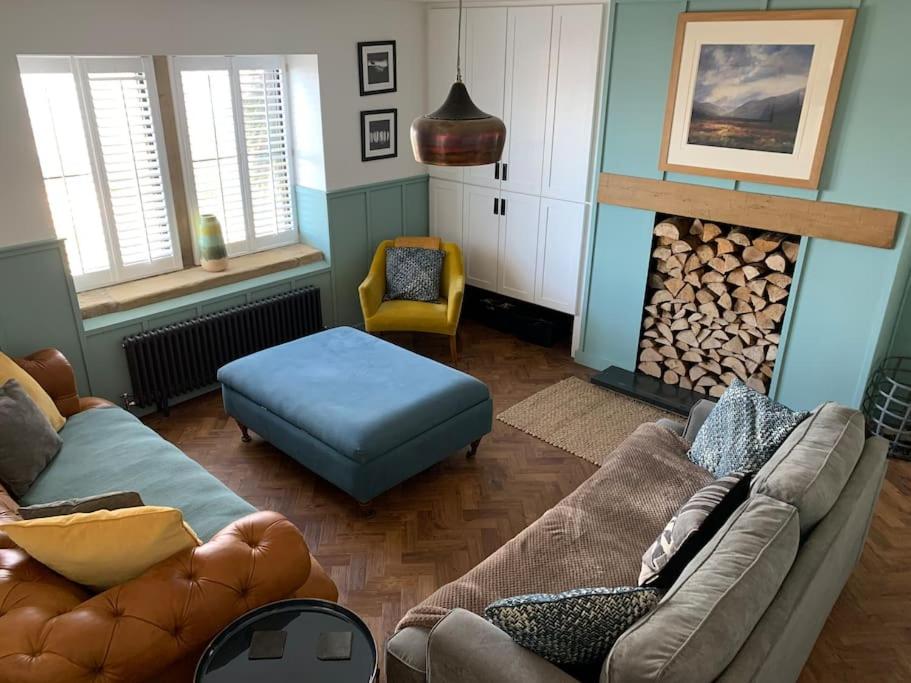 a living room with a couch and a fire place at Luxurious & modern on-the-beach family retreat in Boulmer
