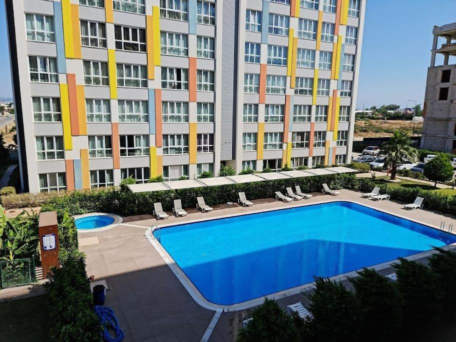 un grand bâtiment avec une piscine en face d'un bâtiment dans l'établissement Lego Residence Pool & Security & City Center & 5 star, à Antalya