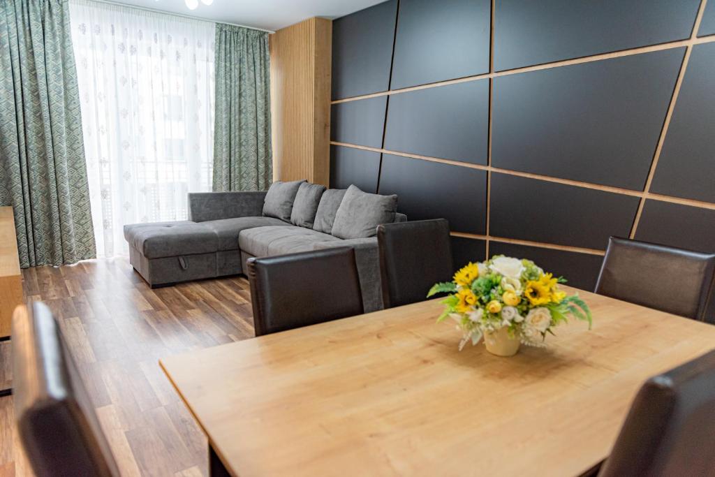 - un salon avec une table et un canapé dans l'établissement Pastel Apartments, à Braşov