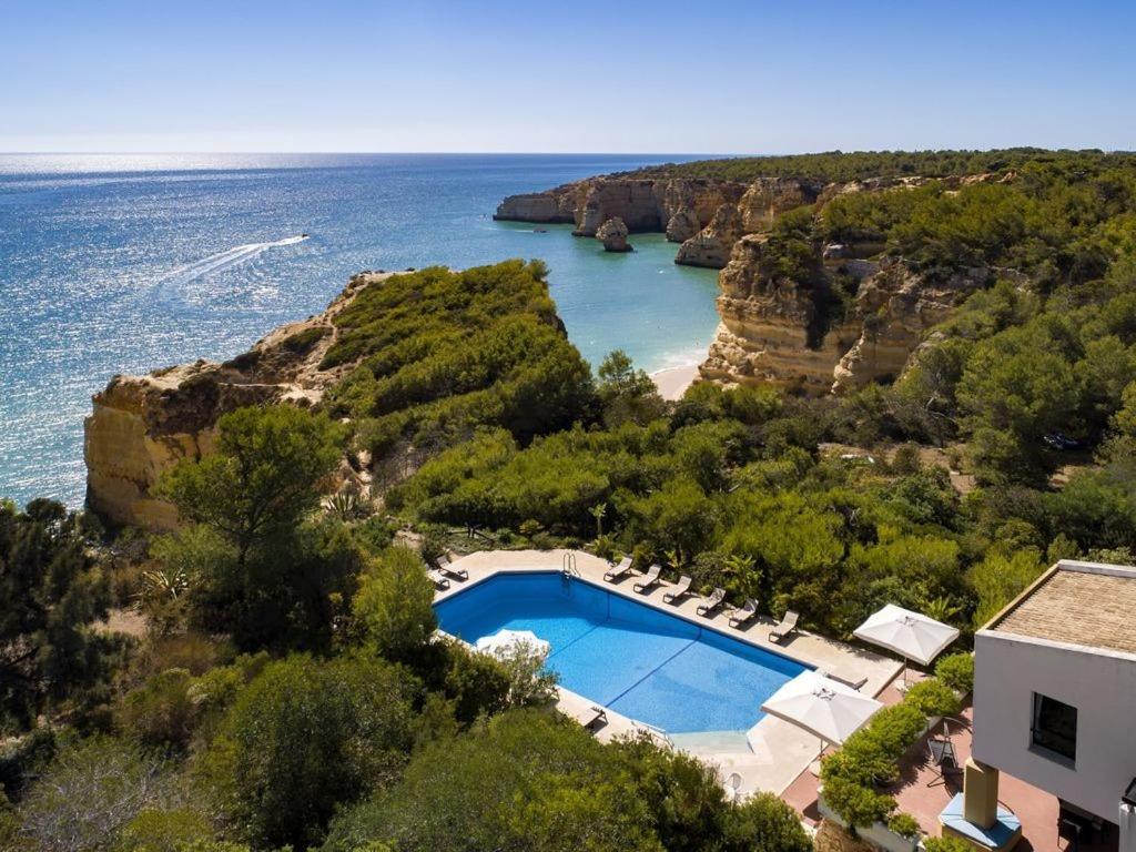 an aerial view of a house with a swimming pool and the ocean at Villa Quinta Marinha - 9 bedroom villa 20 guests stunning location overlooking sea huge private p in Lagoa