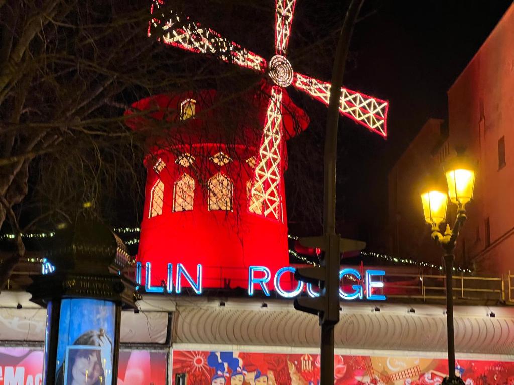 Une grande tour rouge avec une horloge en haut dans l'établissement Eden Moon, à Paris