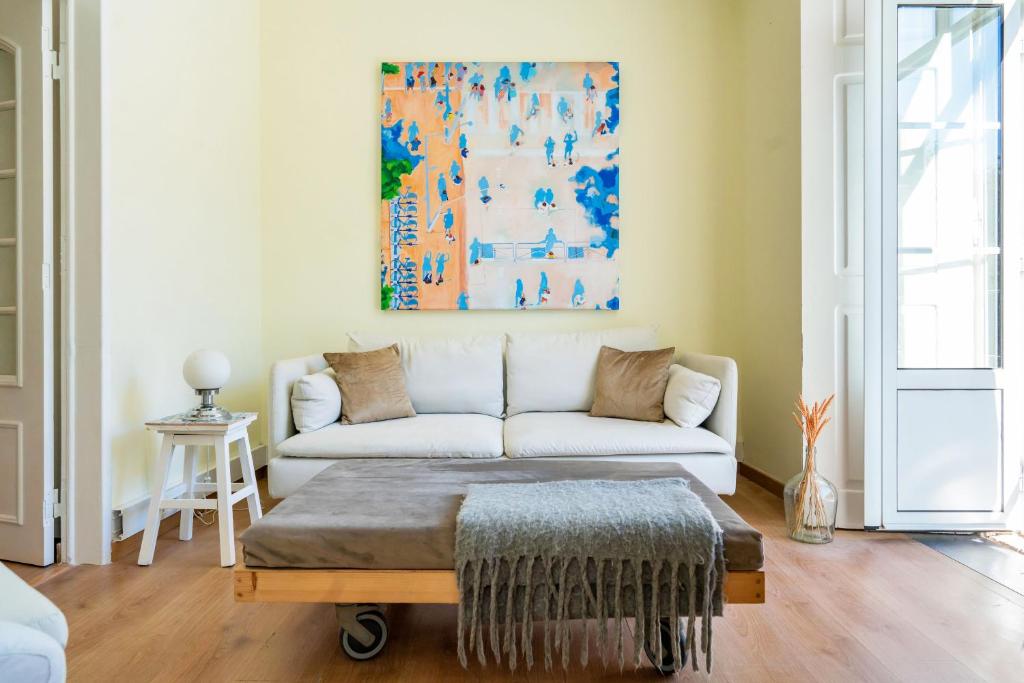 un soggiorno con divano e un dipinto sul muro di Casa St Yves - Sunny flat in Setúbal on Av Luisa Todi a Setúbal