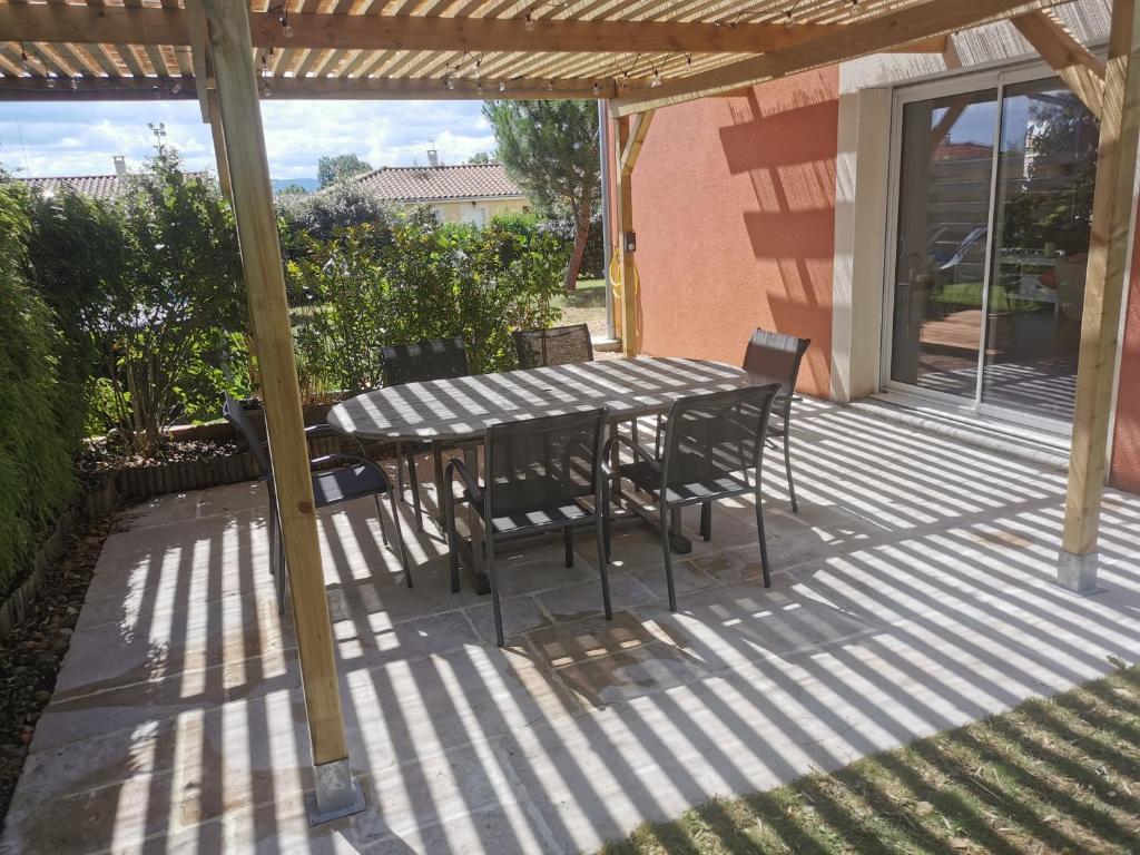 einen Tisch und Stühle auf einer Terrasse in der Unterkunft Villa 8 personnes à proximité des bords de Saône in Montmerle Sur Saône