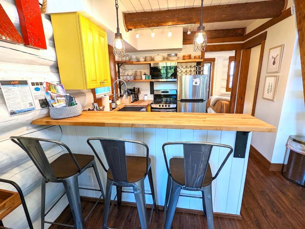 a kitchen with three bar stools and a counter at Black Bear Cabin 3 in Whitefish