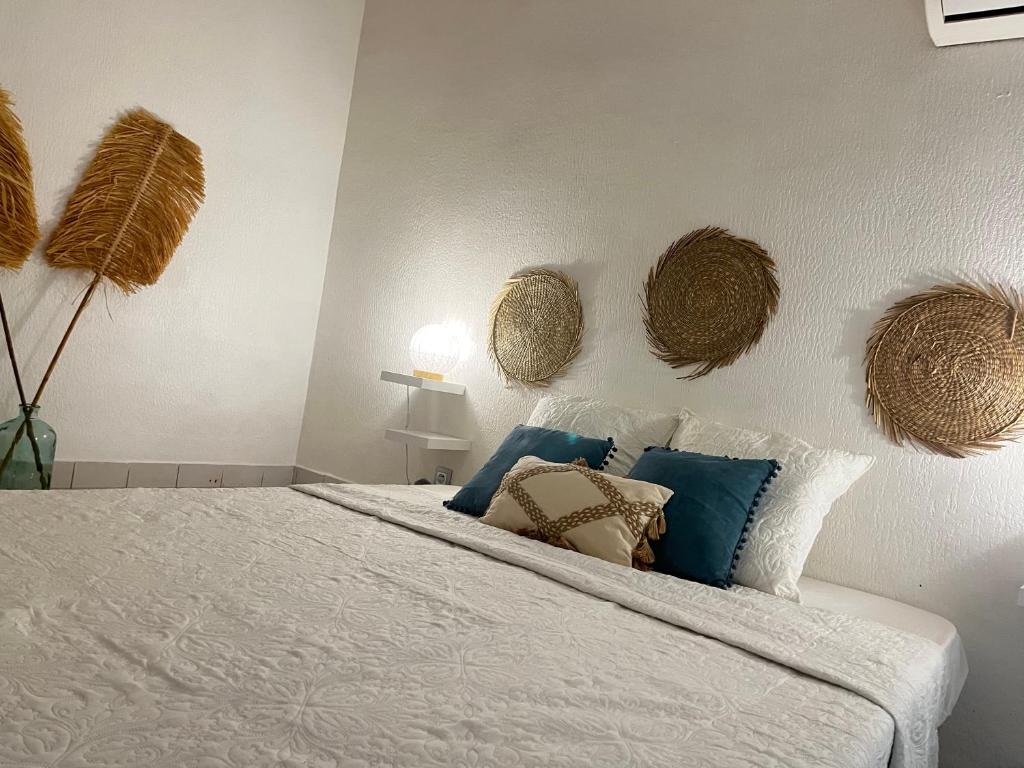 a bedroom with a bed with white sheets and blue pillows at Azuri Lodge Duplex Marina in Saint-François