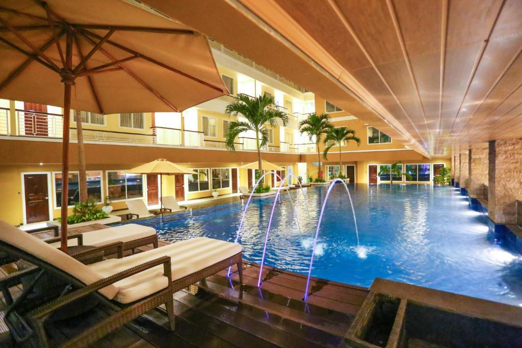 a swimming pool with a fountain in a building at Sylvia Hotel Kupang in Kupang