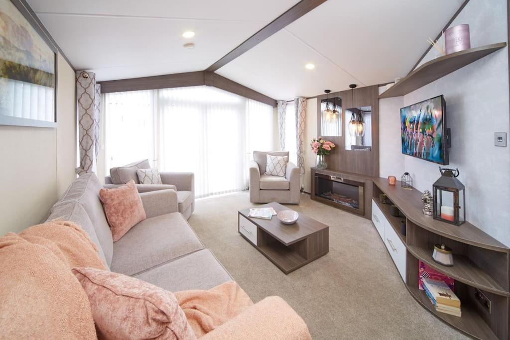 a living room with a couch and a tv at Modern Luxurious Holiday Home with ocean views in Paignton