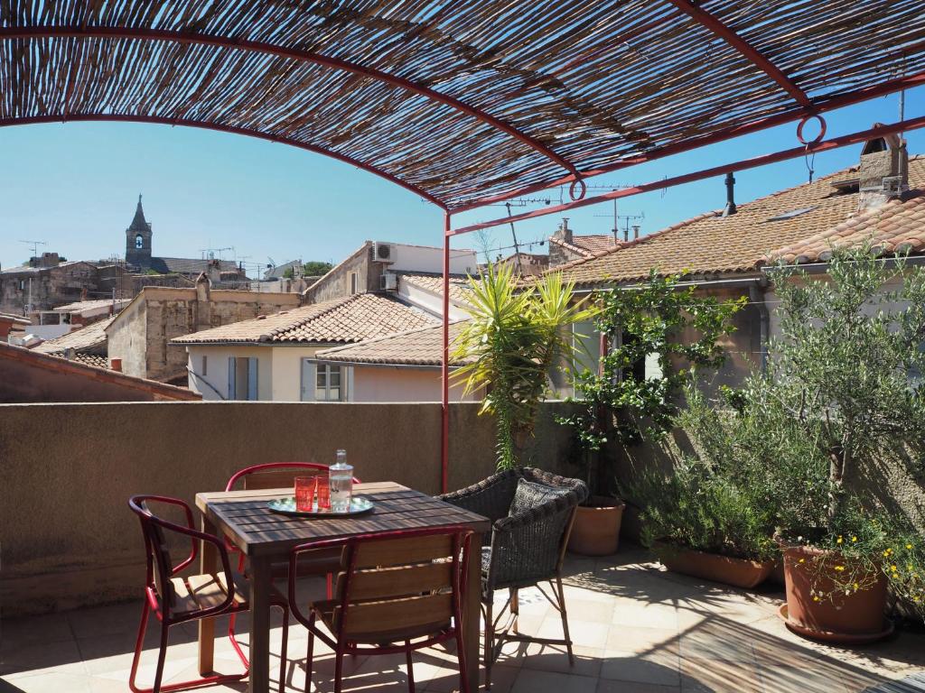 a patio with a table and chairs on a balcony at La Maison Jasmin in Arles