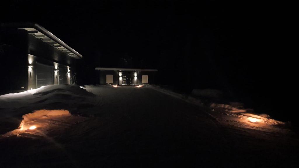 una calle oscura con un edificio de noche con luces en Villa Paatari, Inari (Paadarjärvi), en Inari