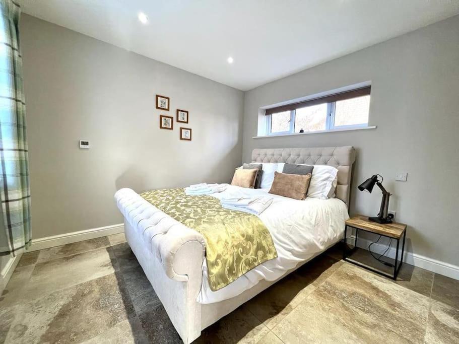 a bedroom with a large white bed in a room at Stylish, Country, Self-Contained Annexe near Cambridge in Colne
