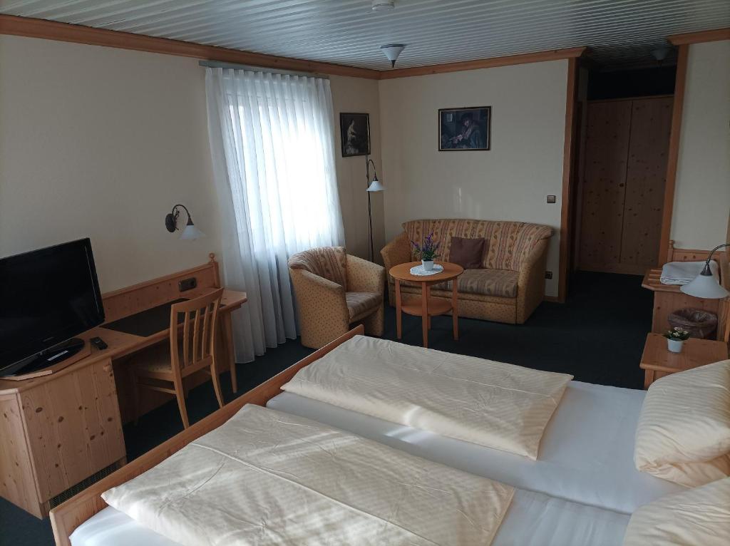 a hotel room with a bed and a living room at Bocksbeutelherberge in Sommerach