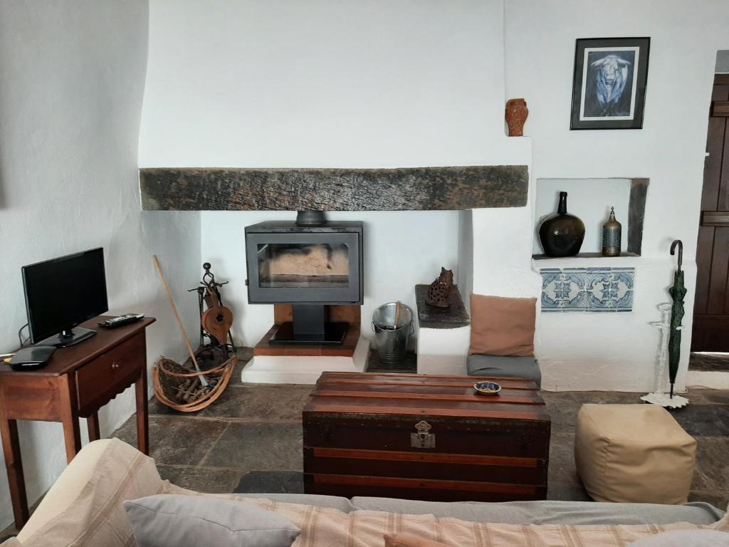 sala de estar con sofá y TV en Casas Letizia e Sebastião, en Monsaraz