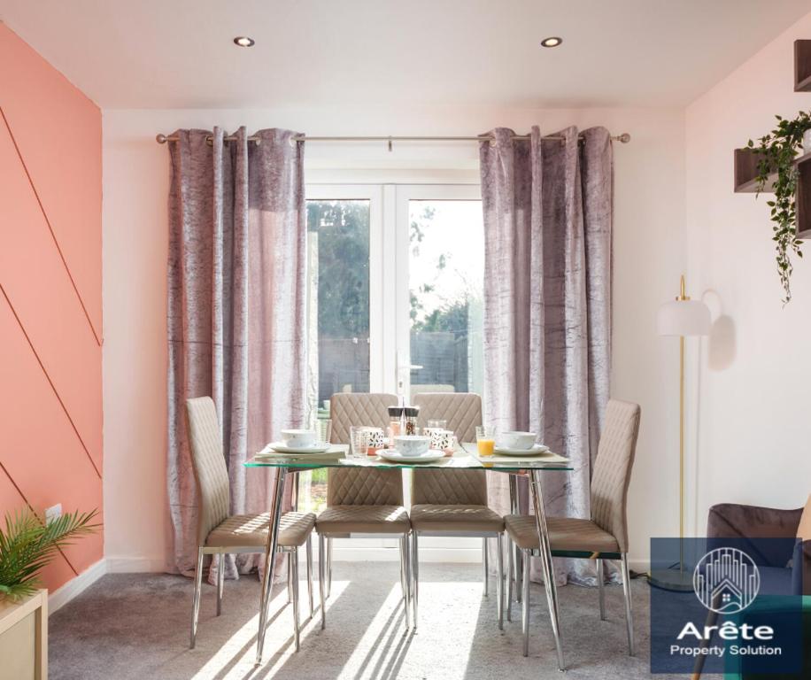 ein Esszimmer mit rosa Wänden sowie einem Tisch und Stühlen in der Unterkunft ENQUIRE NOW - AreteStays providing temporary homes for Families & Business Contractors since 2019 in Merstham