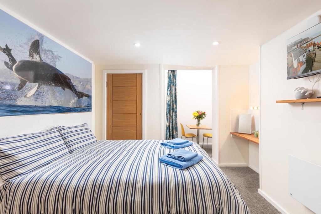 a bedroom with a bed and a painting of a whale at Discovery Accommodation in Whitby