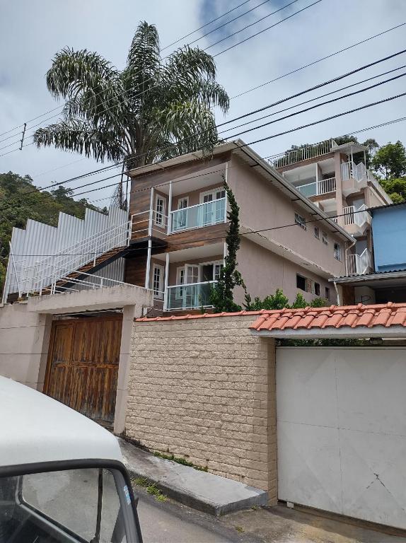 a house with a garage in front of it at Apartamentos Aconchegantes Bingen em Petrópolis in Petrópolis
