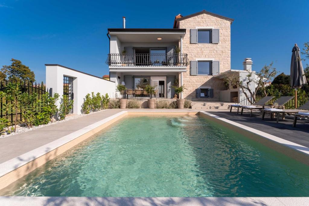 una casa con piscina di fronte a una casa di Villa Contessina by SeeAdria Agency a Novigrad Istria