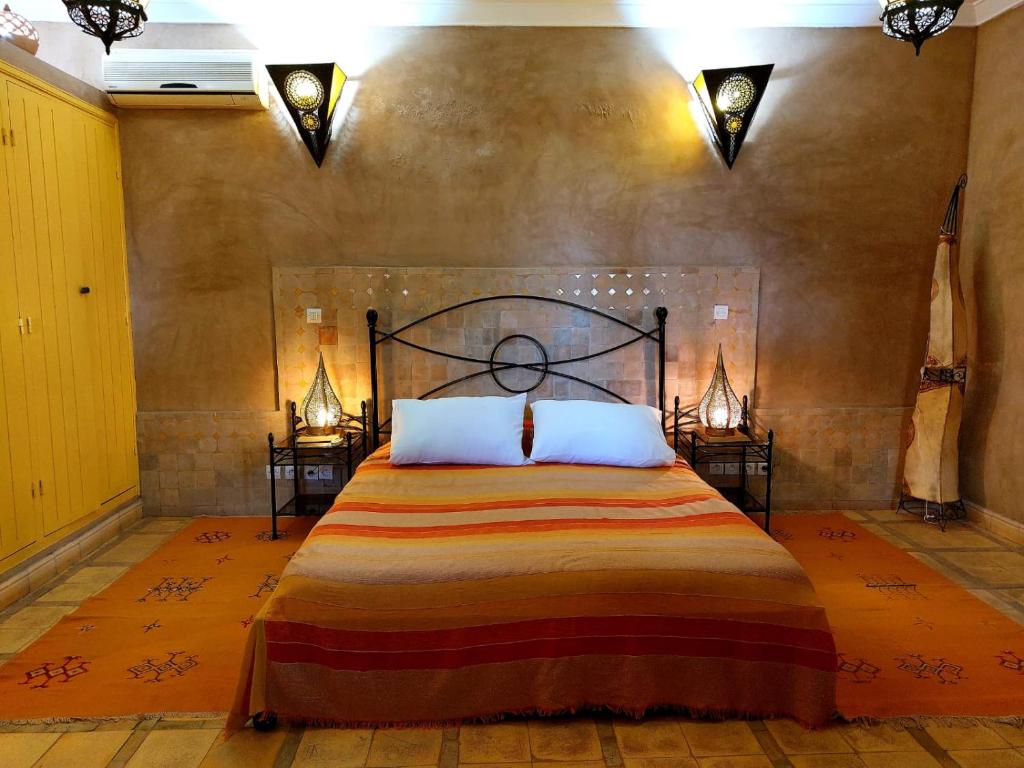 une chambre avec un grand lit avec deux tables de nuit dans l'établissement Riad Ain Khadra, à Taroudant