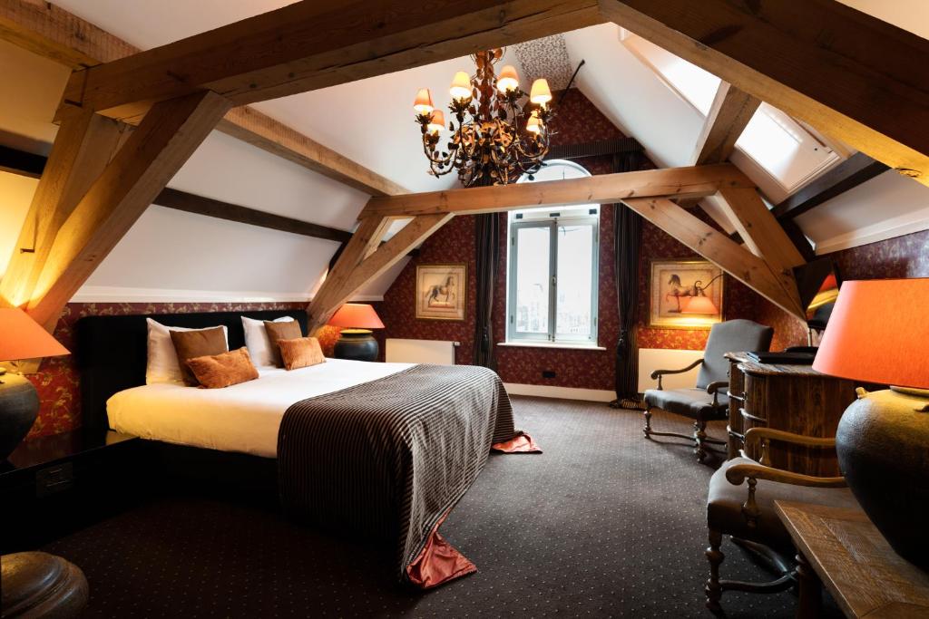 een slaapkamer met een groot bed op zolder bij Grand Boutique Hotel-Restaurant Huis Vermeer in Deventer