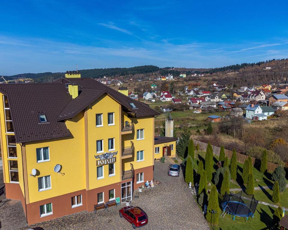 a yellow building with a town in the background at Вілла ЮРАН Східниця in Skhidnitsa