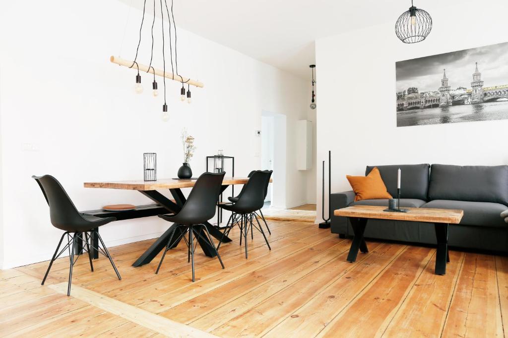 uma sala de estar com uma mesa e cadeiras e um sofá em Be in Berlin Apartments im Bergmannkiez em Berlim