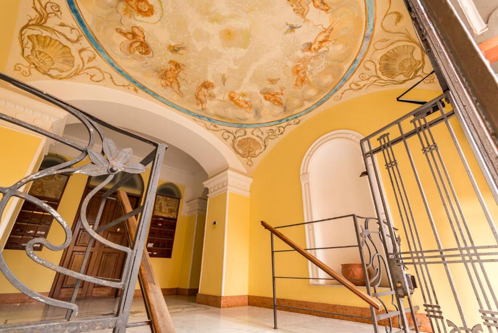 a staircase in a building with a painting on the ceiling at Suite Royal in La Spezia
