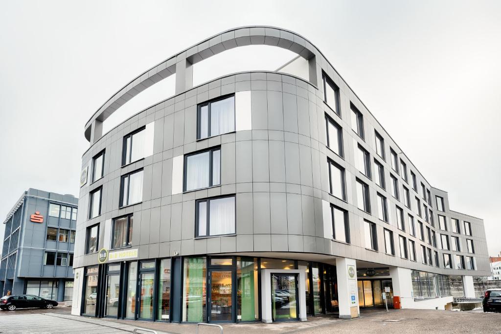 un gran edificio blanco con un arco sobre él en B&B Hotel Aalen, en Aalen