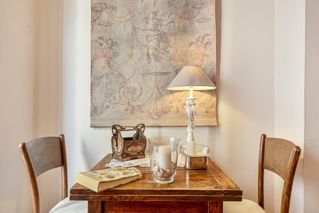 a wooden table with a lamp and a book on it at Suite Royal in La Spezia