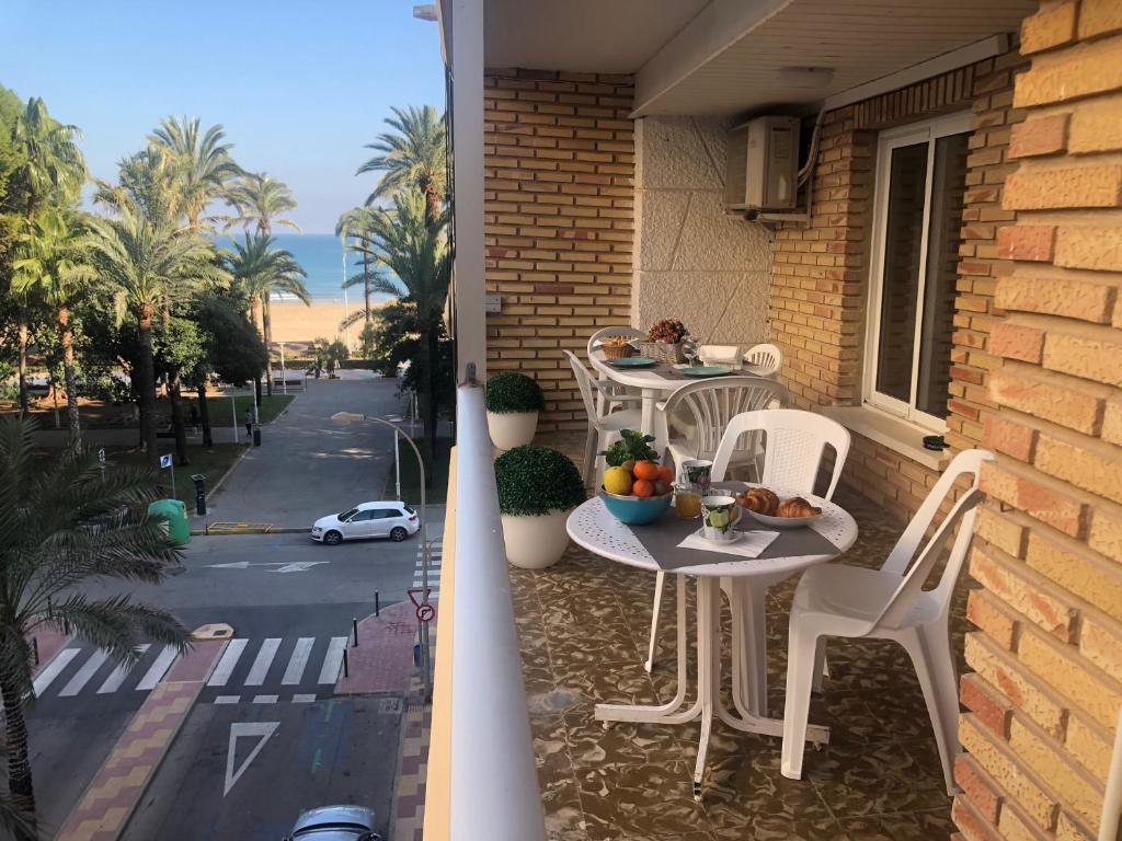 a balcony with two tables and chairs on a house at A 50 m de la plage in Cullera