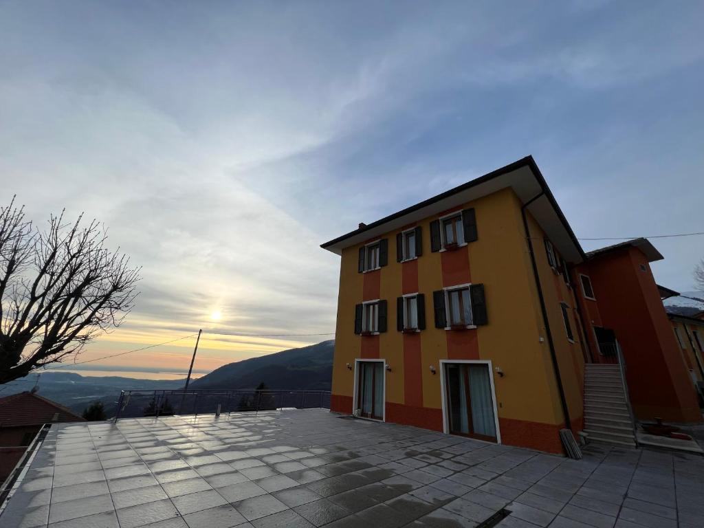 un bâtiment avec un coucher de soleil en arrière-plan dans l'établissement Hotel Belvedere, à Spiazzi Di Caprino