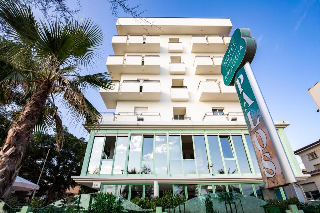 un edificio con un cartello stradale davanti di Hotel Palos a Rimini