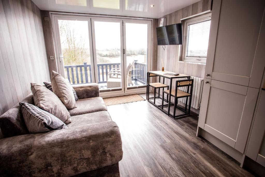 a living room with a couch and a table at Wansbeck Riverside Caravan Park in Ashington