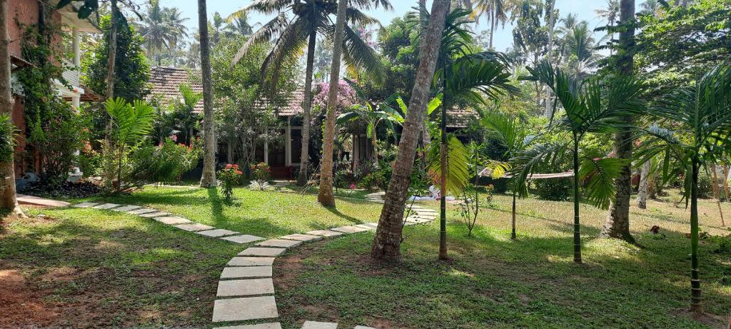 een pad door een tuin met palmbomen bij Doctors Ayurveda Heritage in Varkala