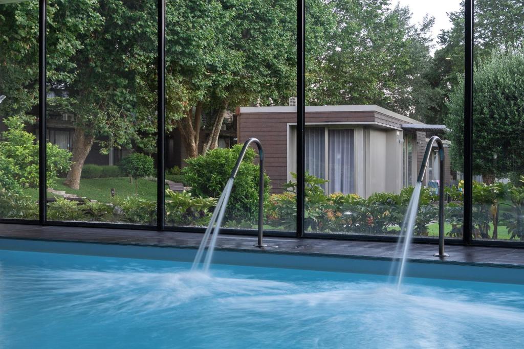 a swimming pool with two fountains in front of a building at Prazer da Natureza Resort & Spa in Caminha