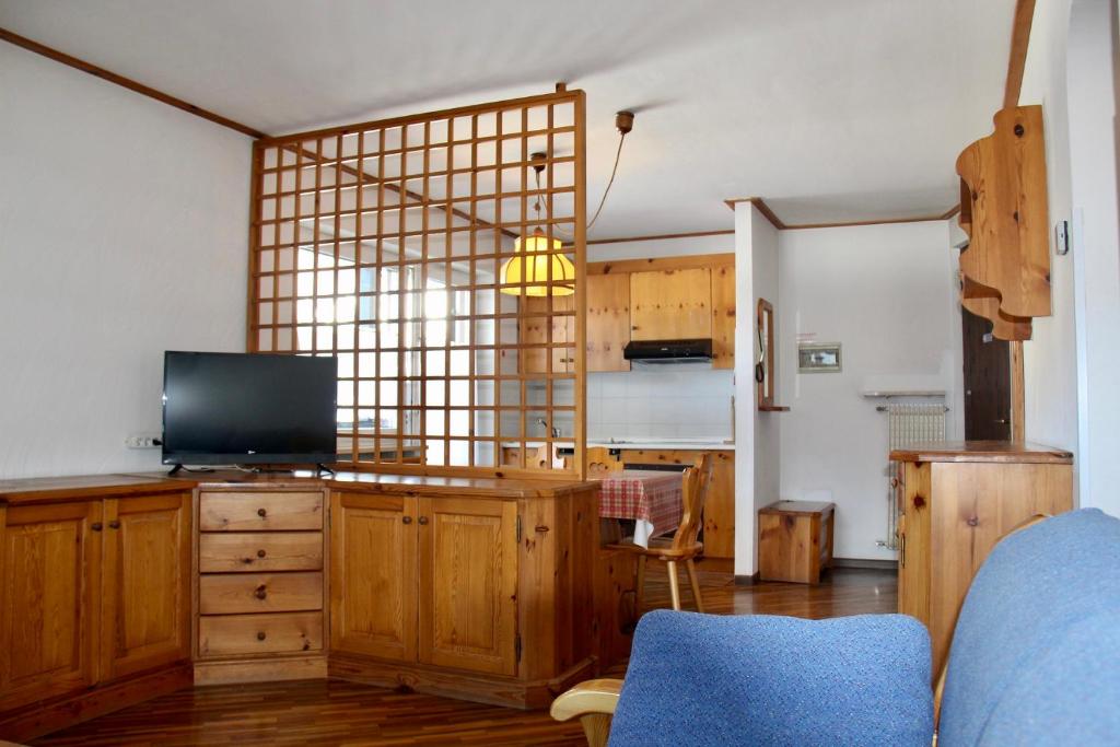 uma sala de estar com uma televisão num armário de madeira em Residence Casa Cavalese em Cavalese