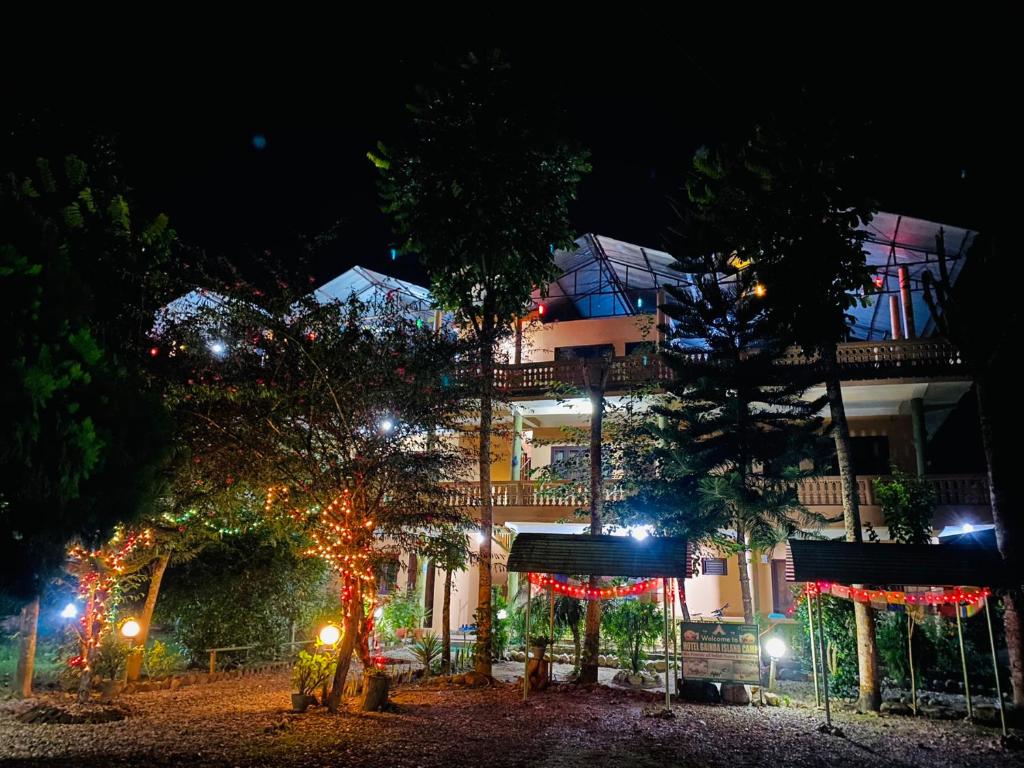 a building with christmas lights in front of it at Hotel Gainda Island Camp in Sauraha
