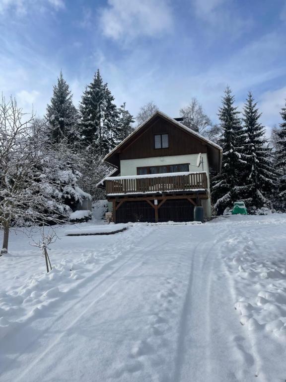 una casa en la nieve con una entrada cubierta de nieve en Chata Monika, en Frymburk