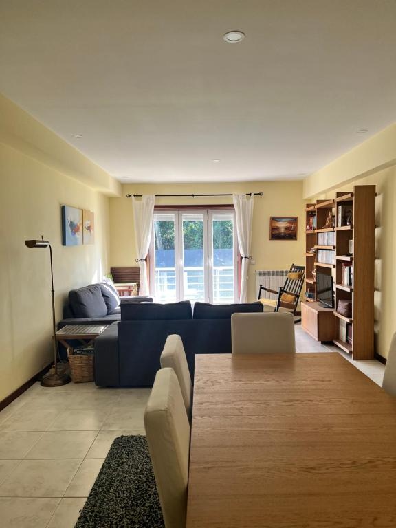a living room with a blue couch and a table at Casa Praia Ofir in Esposende