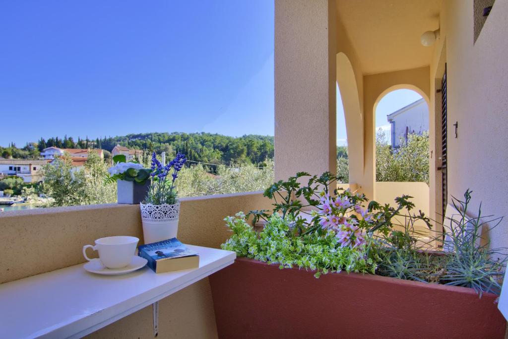 a cup of coffee sitting on a balcony with flowers at Sandy Beach Studio in Lukoran