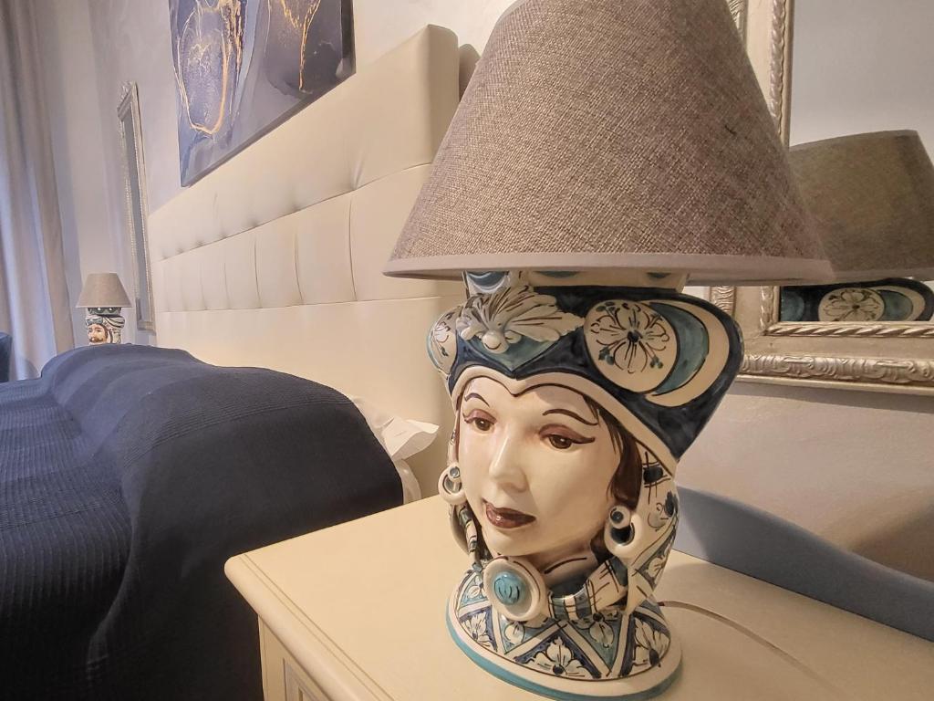 タオルミーナにあるMarifra Flatsのテーブルの上に女性の胸像を載せた灯