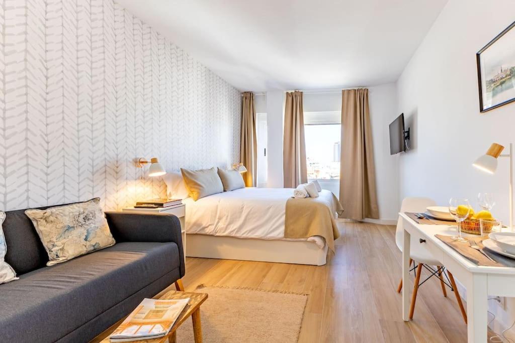 a hotel room with a bed and a couch at NEW Suite reformada con excelente ubicación in Seville