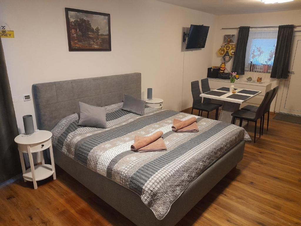 1 dormitorio con 1 cama y 1 mesa con sillas en Honey Apartment Lendava, en Lendava