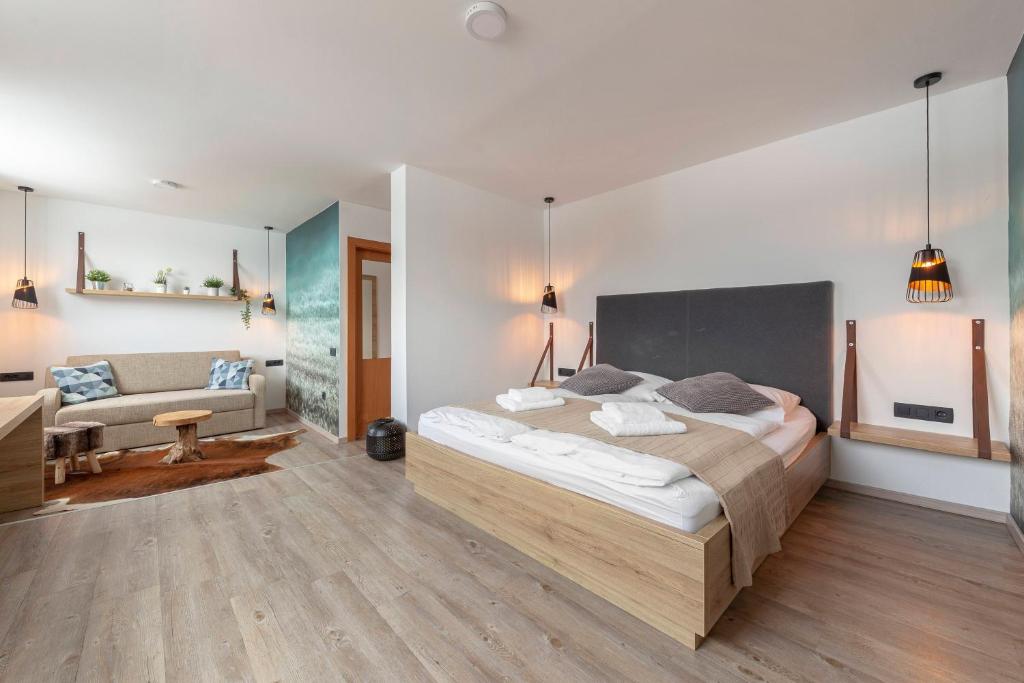 1 dormitorio con 1 cama grande y 1 sofá en Apartments Tabor, en Naklo