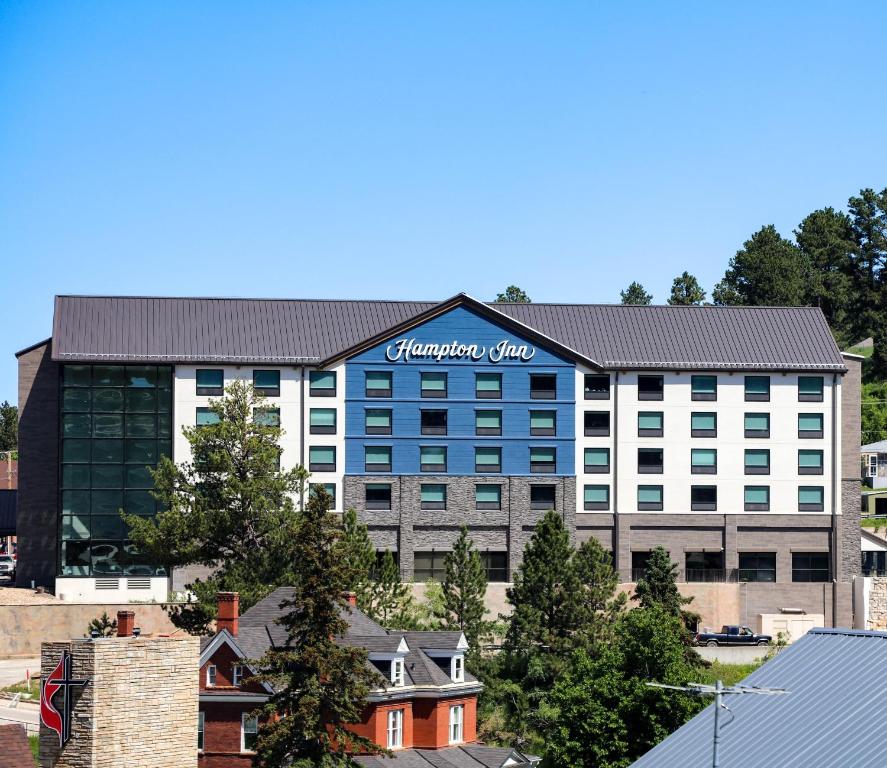 利德Hampton Inn Lead的一座大建筑,上面有标志